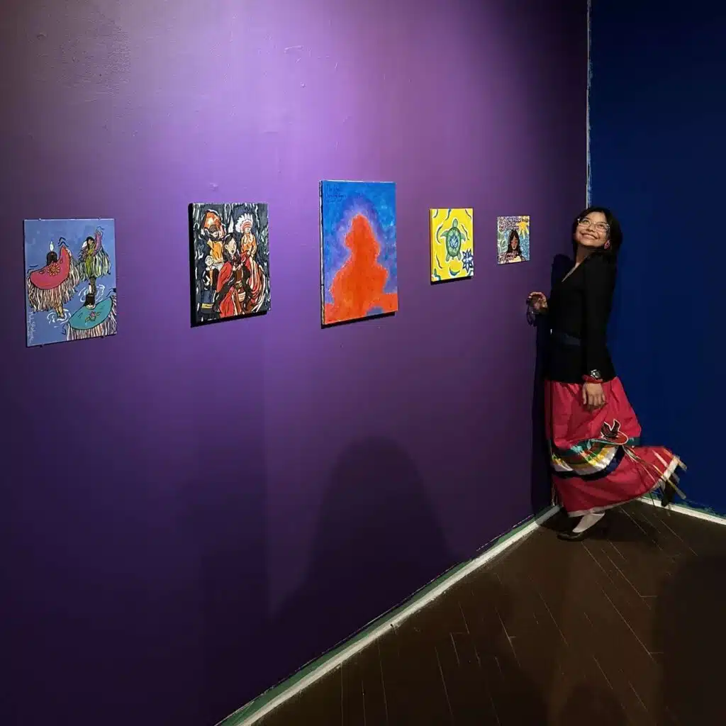 Woman standing in art gallery with purple walls